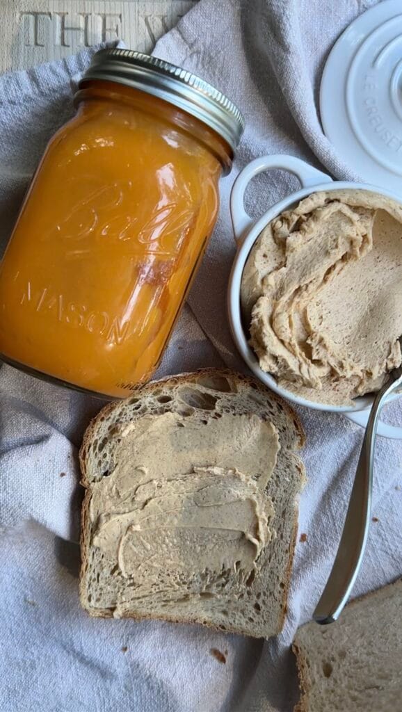 Pumpkin spice butter with sourdough bread and jar on a linen background.