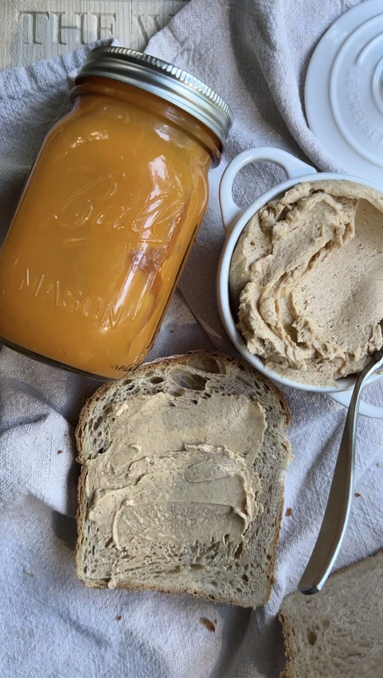 Pumpkin spice butter with sourdough bread and jar on a linen background.