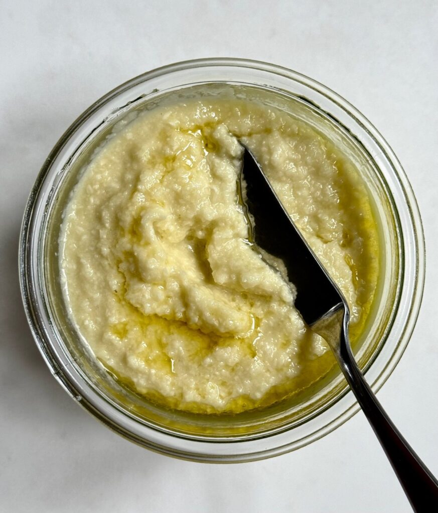 Homemade garlic paste in a glass jar with olive oil on top