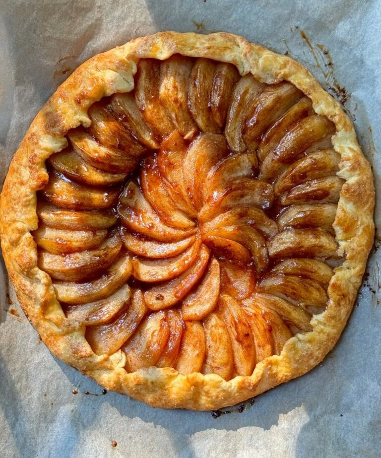 Rustic apple galette with golden flaky crust on parchment
