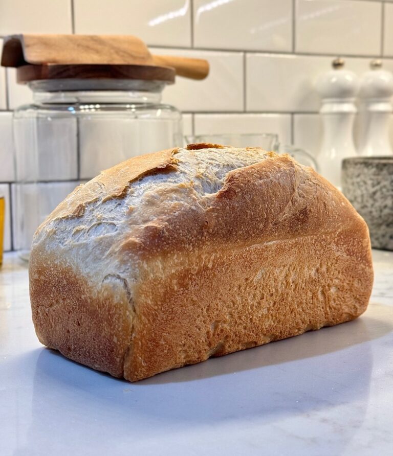 Homemade sourdough sandwich bread with a golden crust on the kitchen counter